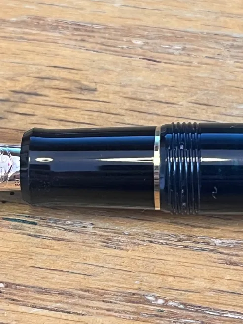 The grip section of the pen, showing how it's a different color compared to the body